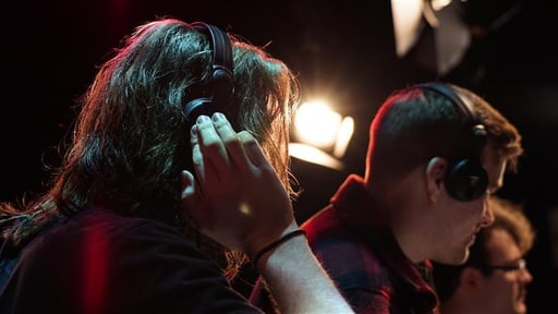 Two people listening to music with headphones.