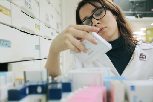 A woman looks for medicines in a medicine cabinet.